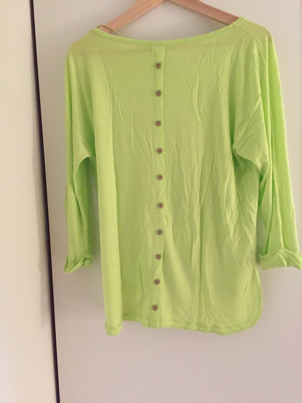 grüner Pullover mit Knöpfen am Rücken 