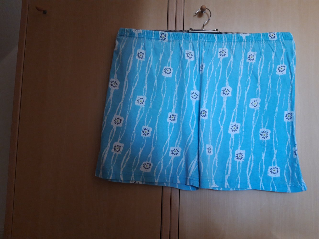blaue Short mit weißem Blumenmuster