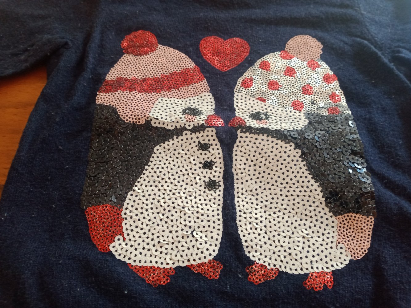 dunkelblauer Pulli mit Pingus aus Pailletten