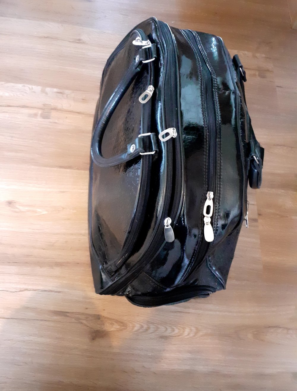 Trolley Reisetasche mit Rollen lackleder PU krokooptik hochglanz schwarz hochglänzend mit vielen Fächern
Griff zum Ziehen praktisch im Reißverschlussfach zu verstauen und Größenverstellbar
Travellback Weekender für Urlaub oder Sport