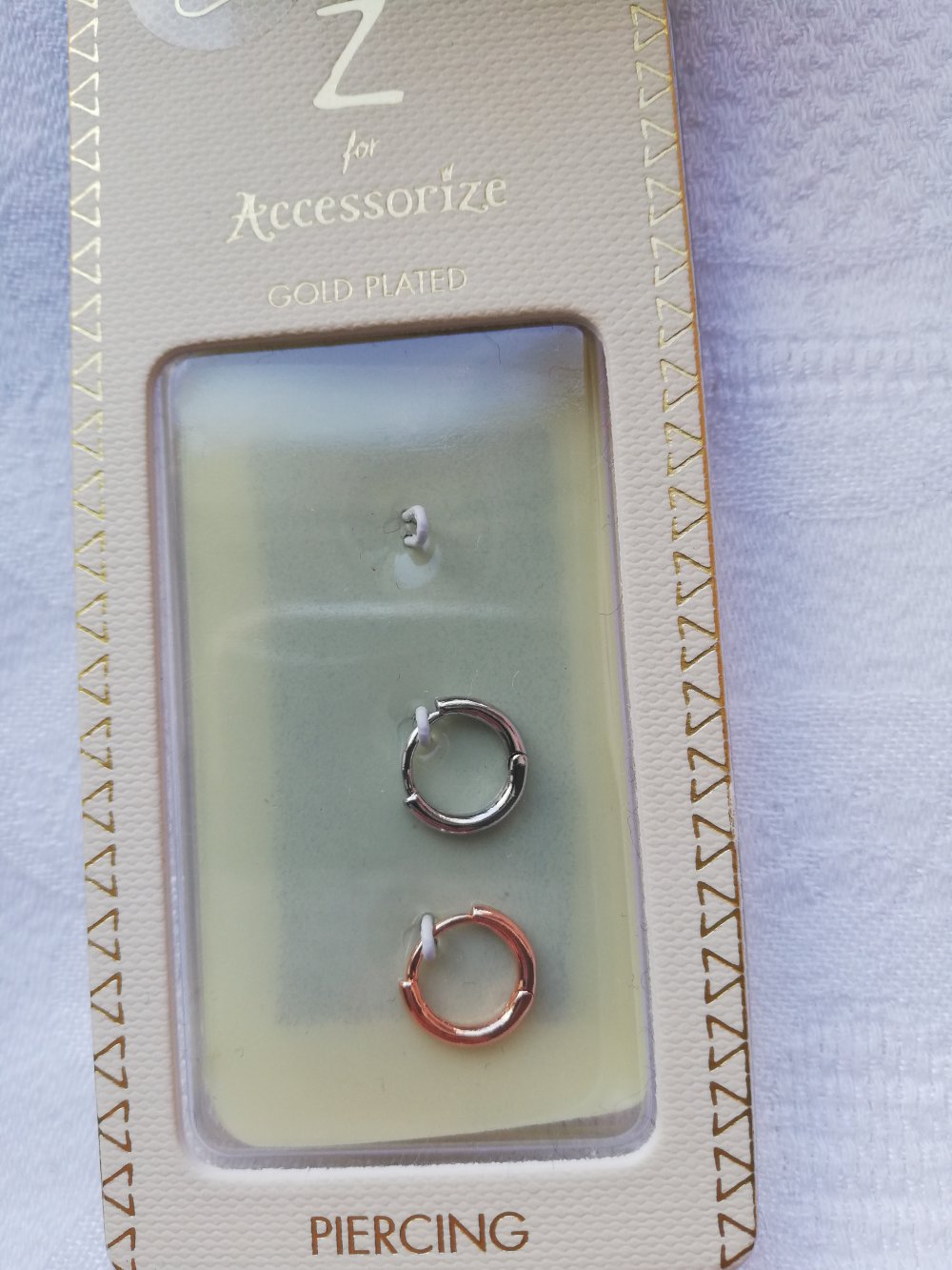Zwei original verpackte Piercings fürs Ohr in Silber und Rosegold von Accessorize