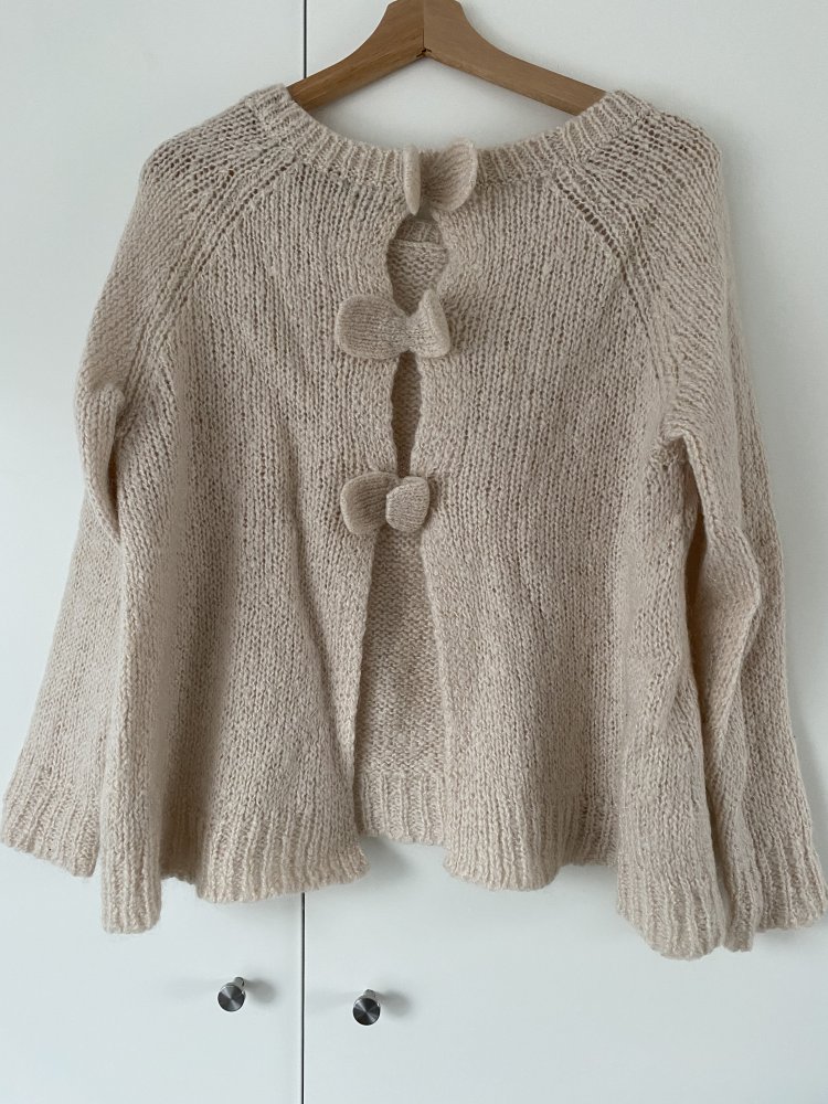 Cremefarbener Strickpullover hinten offen