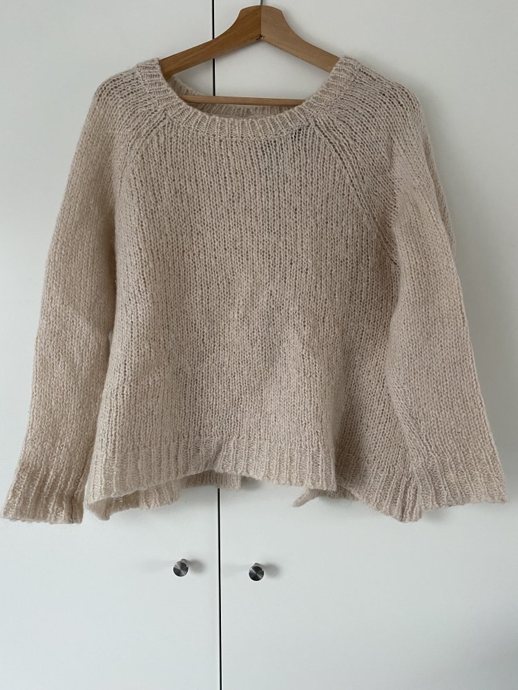 Cremefarbener Strickpullover hinten offen