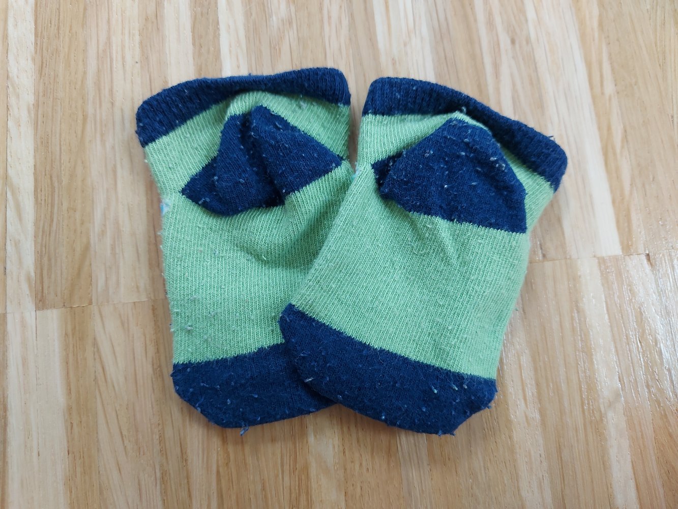 grünblaue Babysöckchen mit Kuh-Motiv 