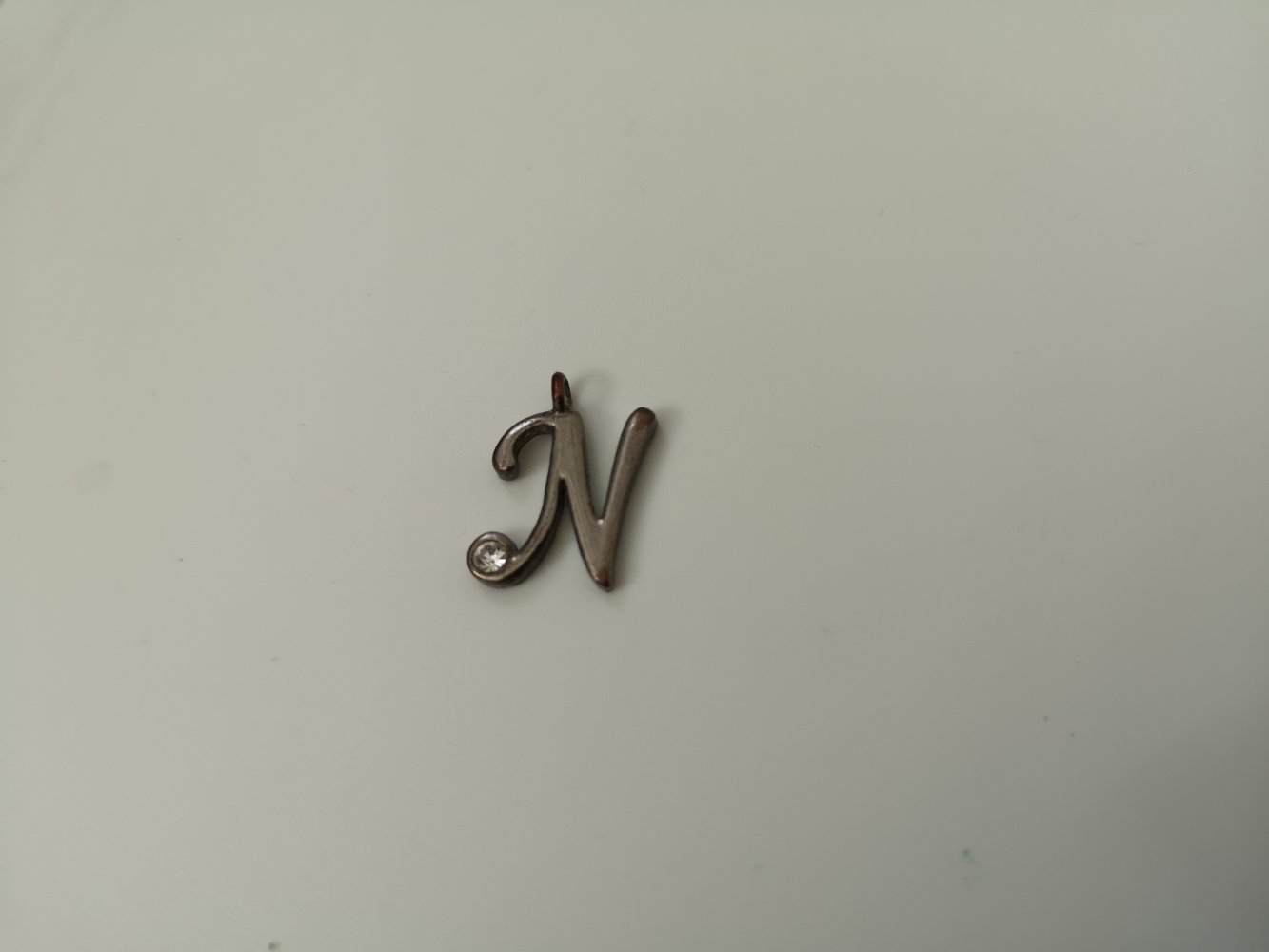 silberfarbener Kettenanhänger mit dem Buchstaben N und Strasssteinen