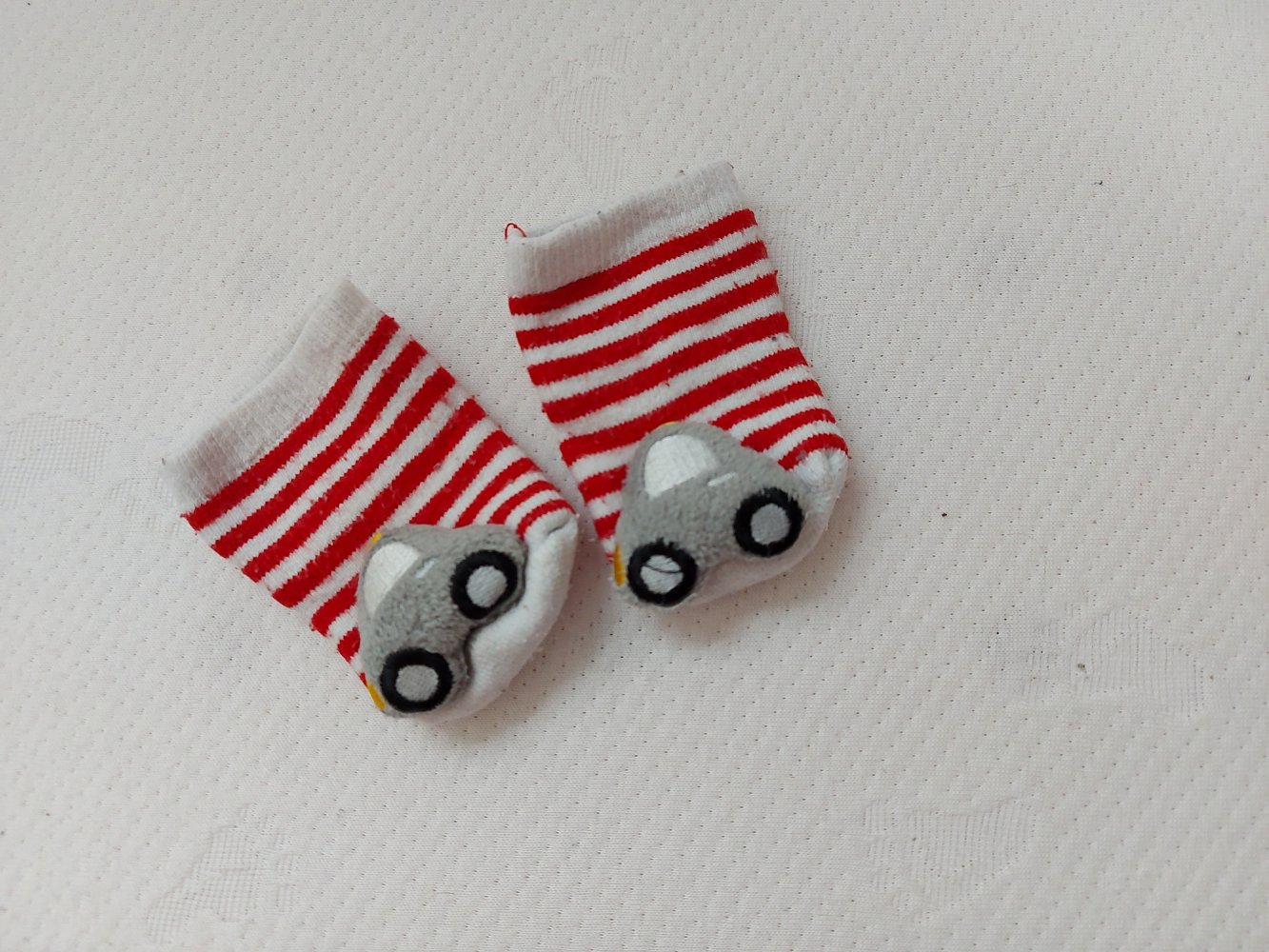 rot-weiß gestreifte Babysocken mit Rasselauto / Rasselsöckchen