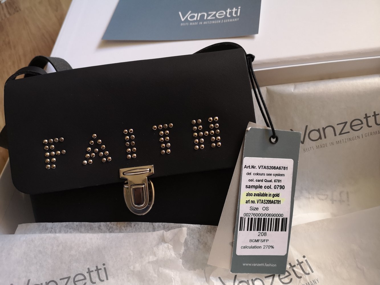schwarze Schultertasche mit der Aufschrift Faith
