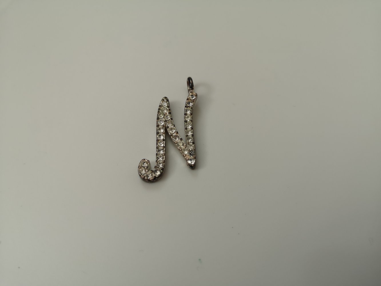 silberfarbener Kettenanhänger mit dem Buchstaben N und Strasssteinen