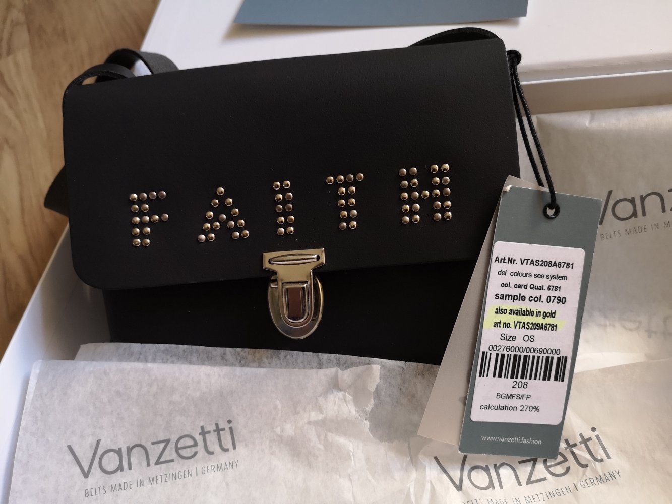 schwarze Schultertasche mit der Aufschrift Faith